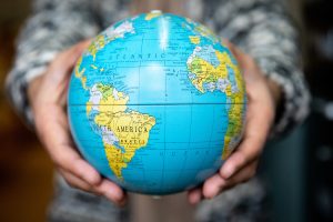 Student holding a globe in their hand