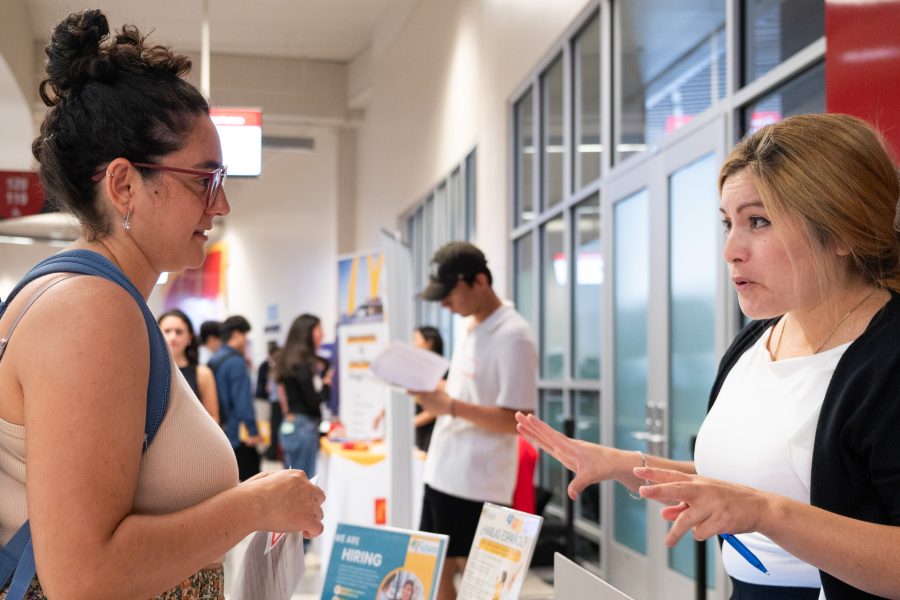 Student at vendor table speaking to employer