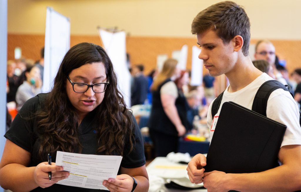 Employer reviewing student's resume at tabling event