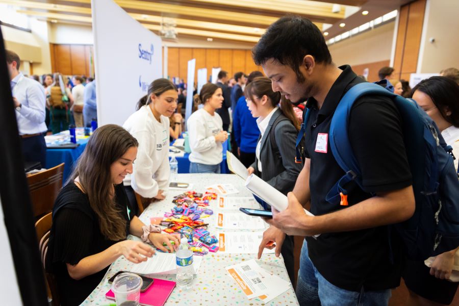 Students standing at employer staffed tables