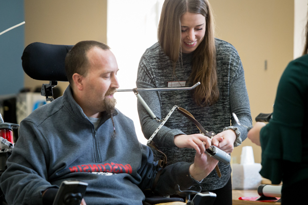 UW Madison student helping someone in a rehabilitation clinic