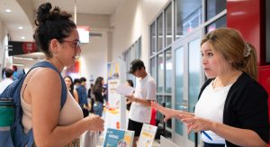 Student at vendor table speaking to employer