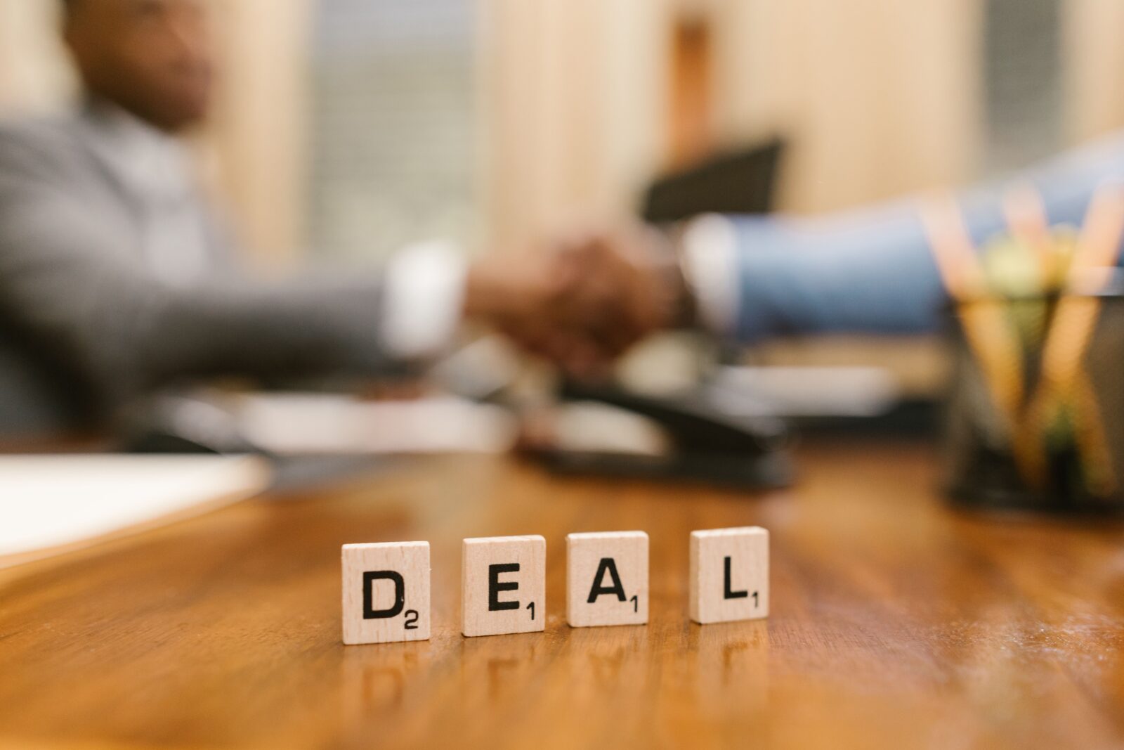 two hands shaking with the word "deal" under them