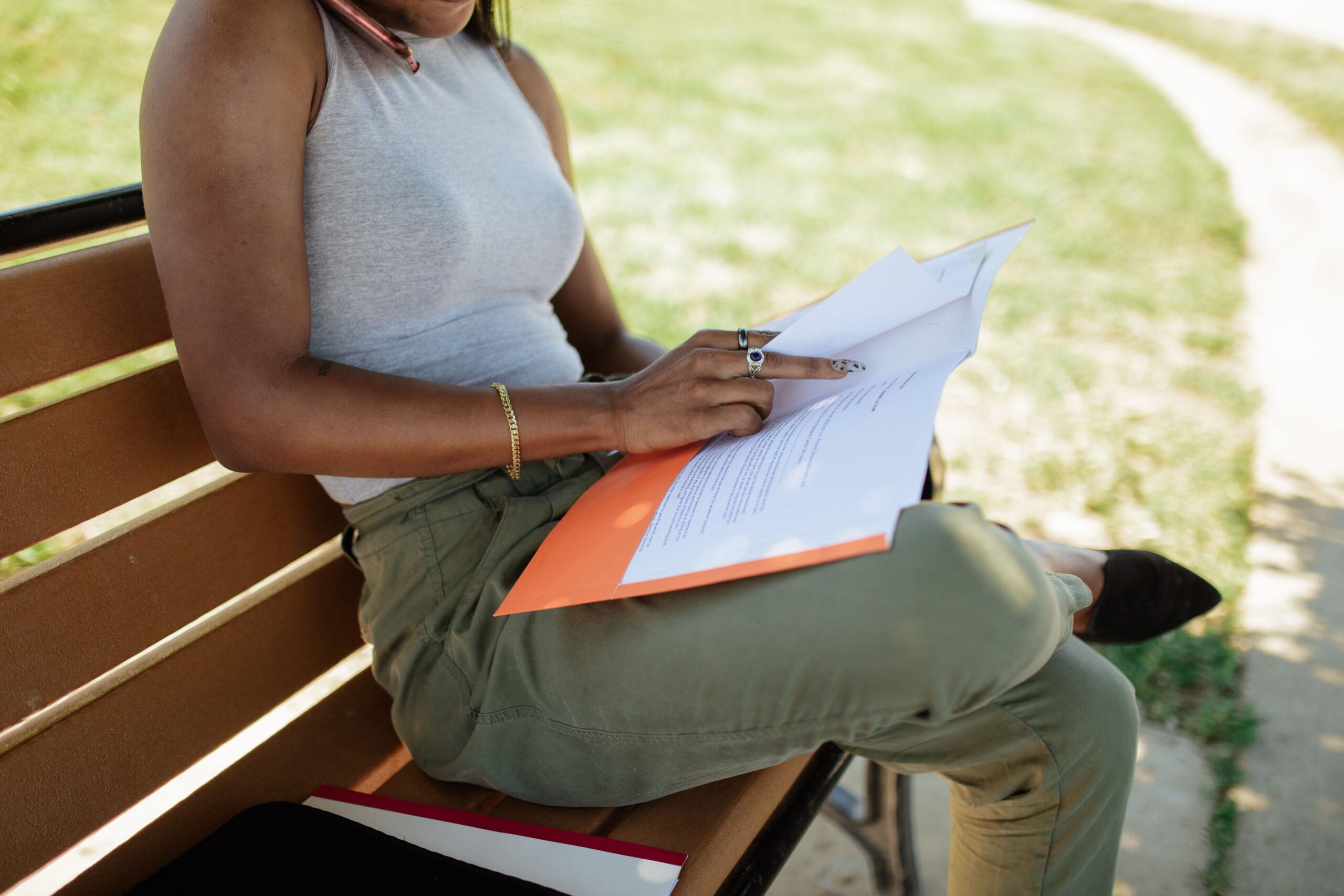 a person sitting on a bench reviewing papers